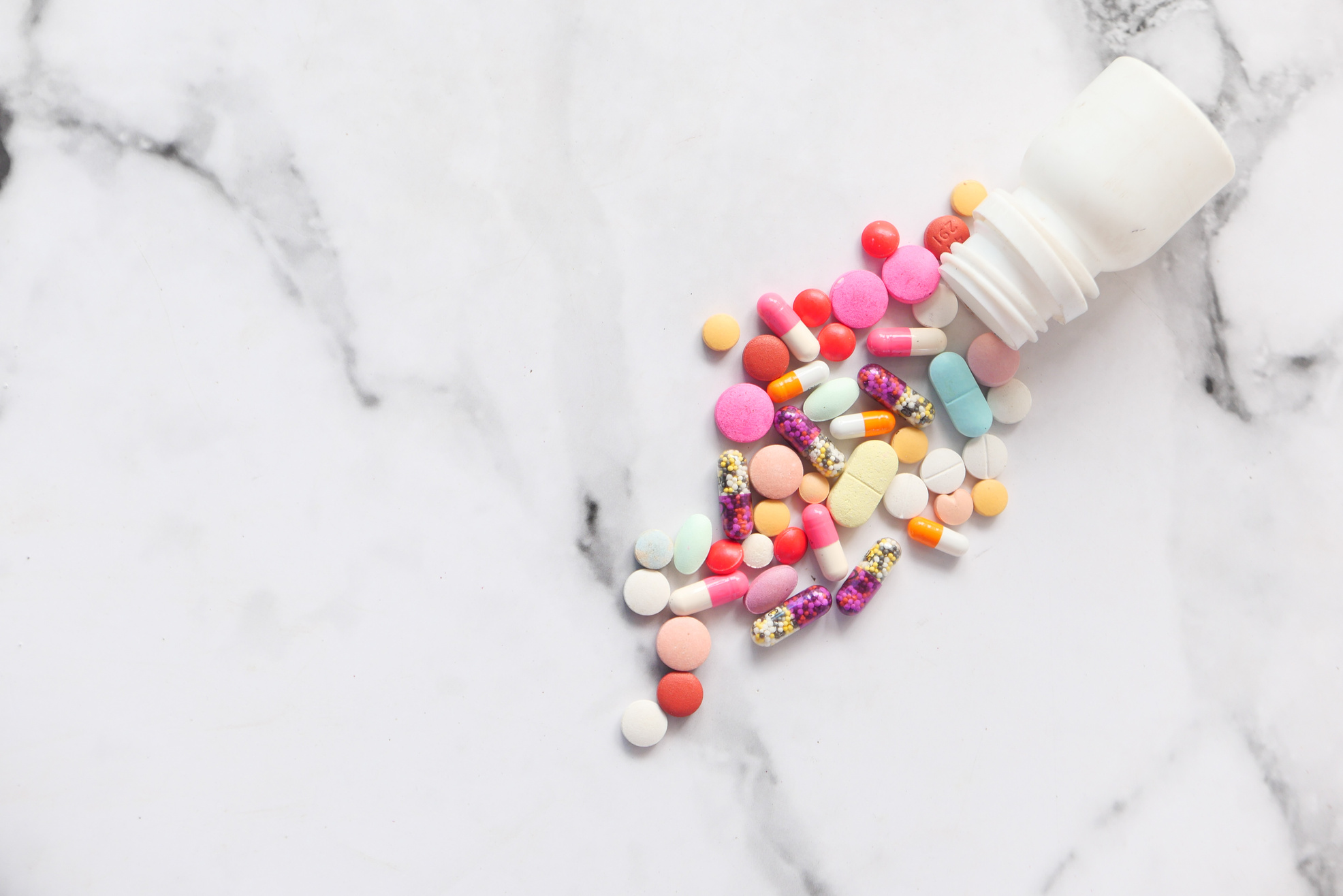 Close up of Colorful Pills Spilling on White Background